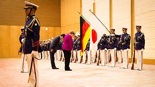 La chancelière fédérale Angela Merkel s'incline lors de l’accueil avec les honneurs militaires