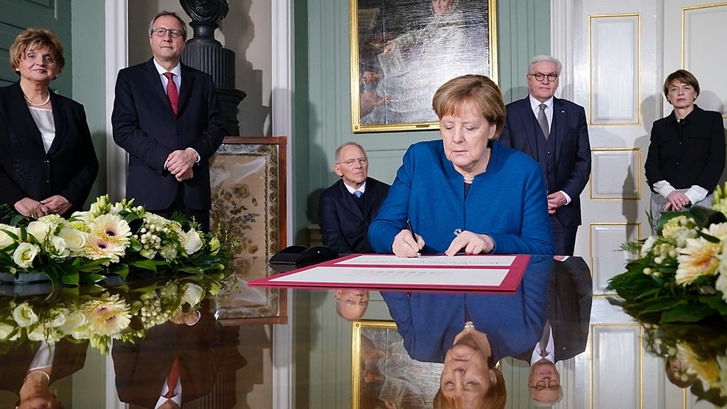 La chancelière fédérale Angela Merkel signe un feuillet commémoratif à Weimar pour le centenaire de l’assemblée nationale