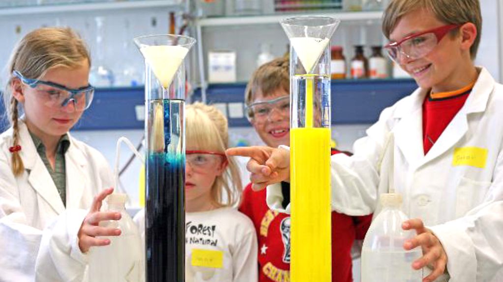 Four children conduct an experiment in a laboratory.