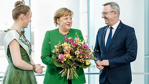 Jürgen Mertz and Lea Ehlers, Germany's "flower fairy" 2018/2019, present the Chancellor with a Valentine's Day bouquet.