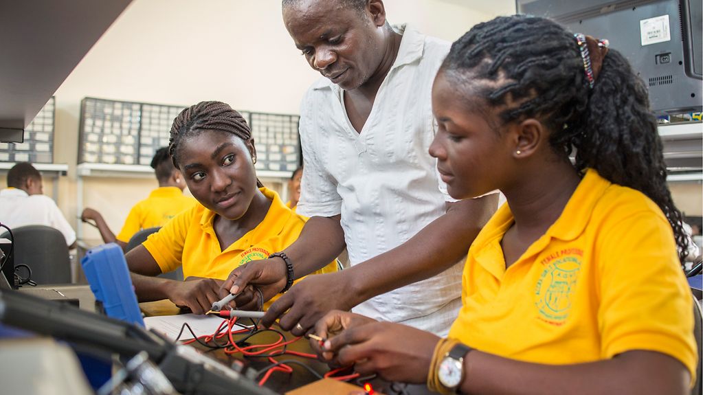 eine Berufsschule fuer Maedchen. Hier unterrichtet ein AusbiBild mit einem Ausbilder und zwei afrikanischen Mädchen in Elektrotechnik, Accra, 08.09.2016. 