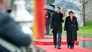 Chancellor Angela Merkel welcomes Latvia's President Krišjānis Kariņš with military honours.