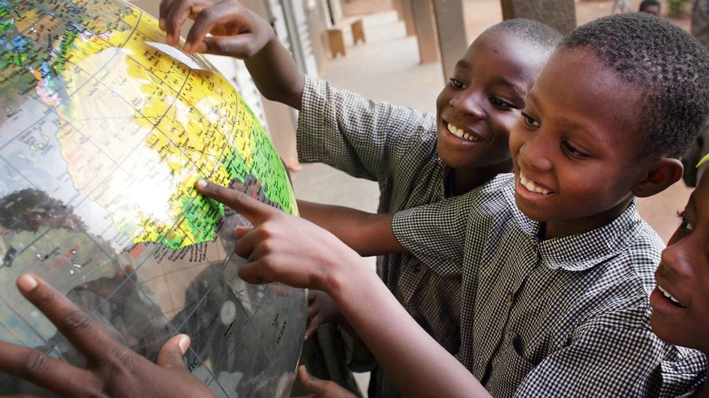 Schulkinder mit Globus in Ouagadougou, Burkina Faso