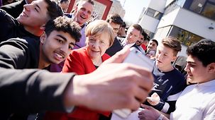 Bundeskanzlerin Angela Merkel wird beim Eintreffen am Thomas-Mann-Gymnasium von Schülerinnen und Schülern begrüßt..