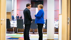 Chancellor Angela Merkel in conversation with French President Emmanuel Macron