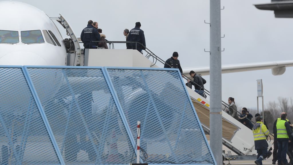 Abgelehnte Asylbewerber steigen in ein Flugzeug. Sie werden von Bundespolizisten begleitet.