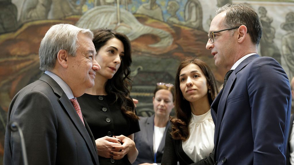 VN-Generalsekretaer Antonio Guterres, Rechtsanwaeltin Amal Clooney, Friedensnobelpreistraegerin Nadia Murad und Außenminister Heiko Maas stehen beieinander und besprechen sich.
