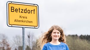 Projektleiterin Sarah Brühl vor einem Ortsschild von Betzdorf.
