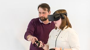 Sascha Hensel zeigt Chiara Brühl eine VR-Brille