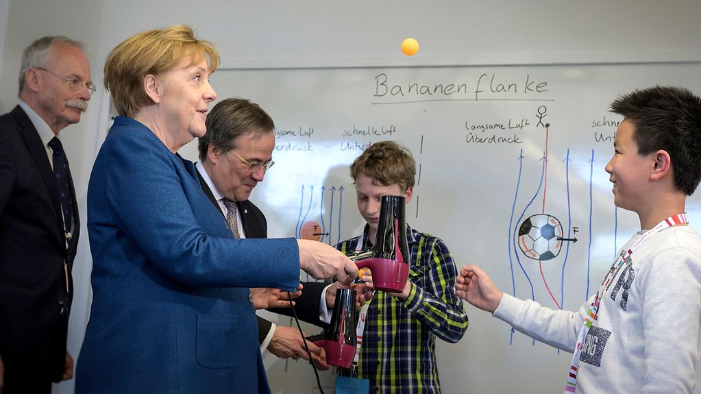 Bundeskanzlerin Angela Merkel experimentiert beim Besuch der Junior Universität Wuppertal.