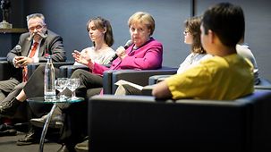 Bundeskanzlerin Angela Merkel diskutiert beim Besuch im Naturkundemusem mit Schülern.