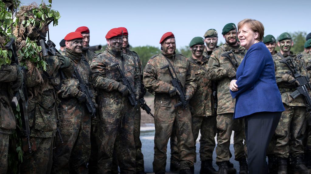 Chancellor Angela Merkel talks to soldiers during her visit to the Very High Readiness Joint Task Force Land.