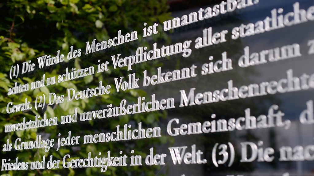 Auf einer Glastafel vor dem Bundestagsgebäude in Berlin steht auch der Artikel 1 des Grundgesetzes.