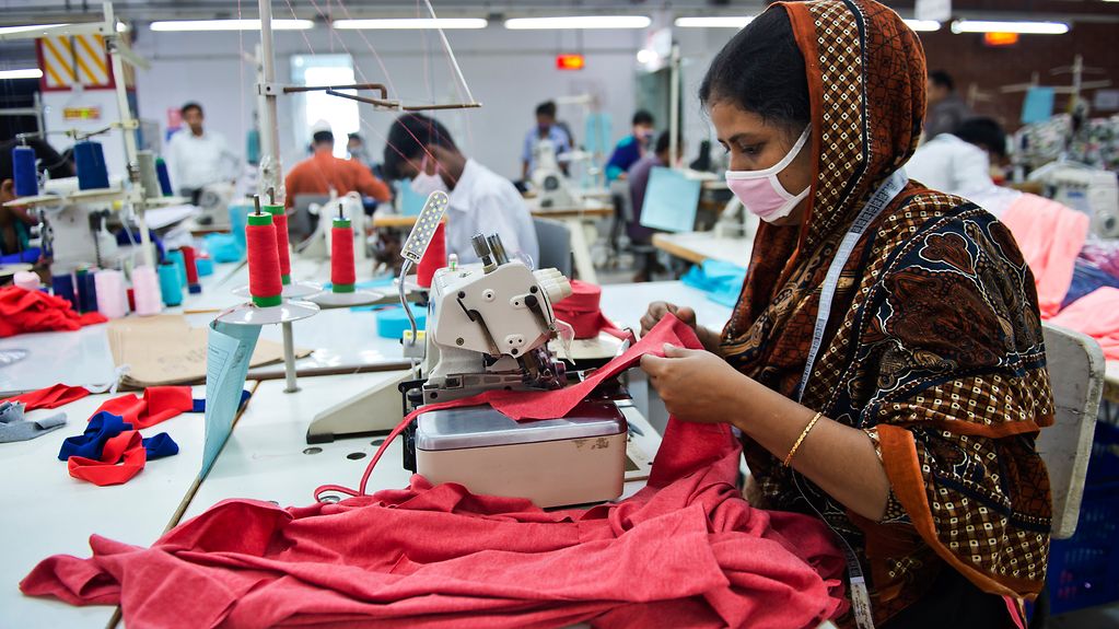 Eine Schneiderin an der Naehmaschine in der Textilfabrik der GBL Group, dem ersten Partnerunternehmen des Textilbuendisses in Bangladesch.