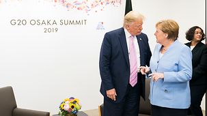 Chancellor Angela Merkel in conversation with President Donald Trump at the G20 summit in Osaka