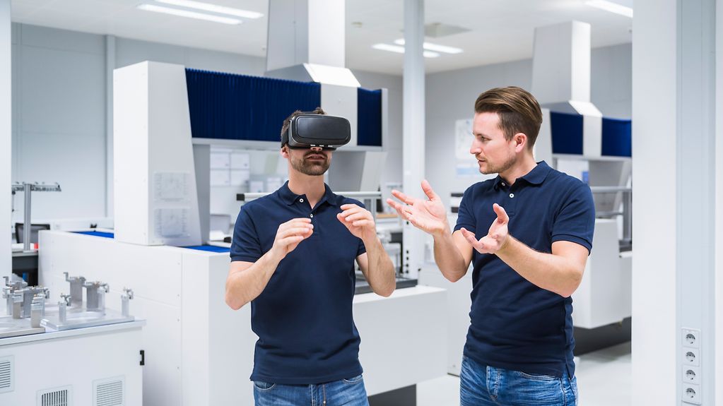 Zwei Männer im Testgerätraum mit VR-Brille.