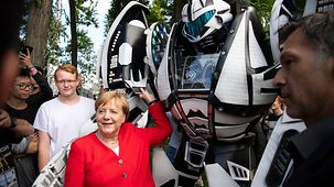 Bundeskanzlerin Angela Merkel beim Rundgang anlässlich des Tags der offenen Tür der Bundesregierung mit einem Roboter der Gamescom.r 
