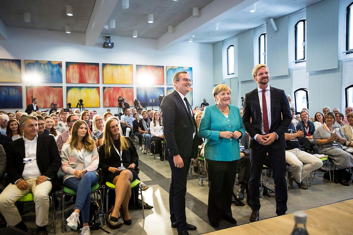 Chancellor Angela Merkel with Andreas Ebel, editor in chief of the newspaper Ostsee-Zeitung, and Gordon Repinski, head of the Berlin office and deputy editor of RedaktionsNetzwerk Deutschland.