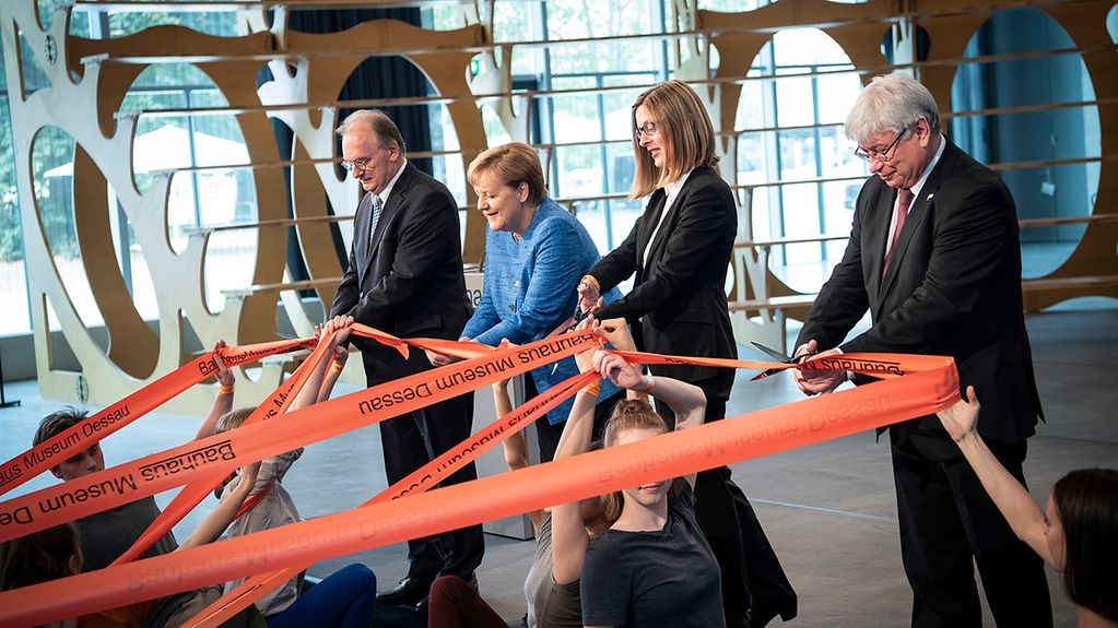 Chancellor Angela Merkel and other guests of honour cut the red tape to officially open the Bauhaus Museum in Dessau.