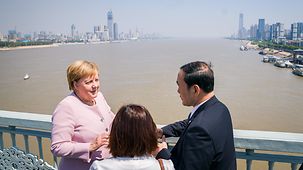 La chancelière fédérale Angela Merkel s’entretient sur un pont surplombant le Yangzi Jiang avec le gouverneur de la province