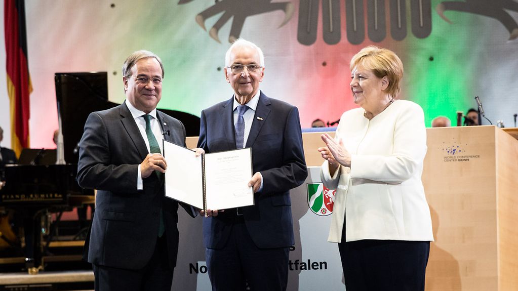 Chancellor Angela Merkel applauds as Klaus Töpfer is awarded the State Prize of North Rhine-Westphalia.