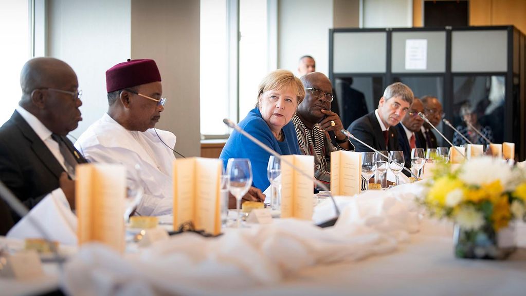 Angela Merkel sitzt am Tisch gemeinsam mit Vertretern afrikanischer Staaten.