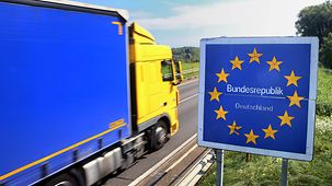 Un camion passe devant un panneau européen à la frontière franco-allemande