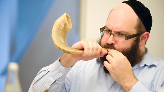 Ein Rabbiner bläst den Schofar, ein Widderhorn.