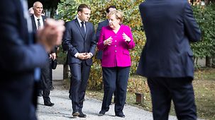 Chancellor Angela Merkel in discussion with French President Emmanuel Macron