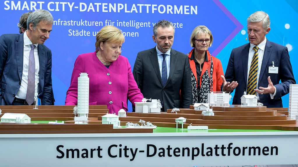 Bundeskanzlerin Angela Merkel vor einem Exponat zu "Smart City".
