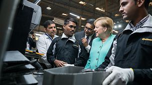 Chancellor Angela Merkel talks to staff during a tour of a Continental plant.