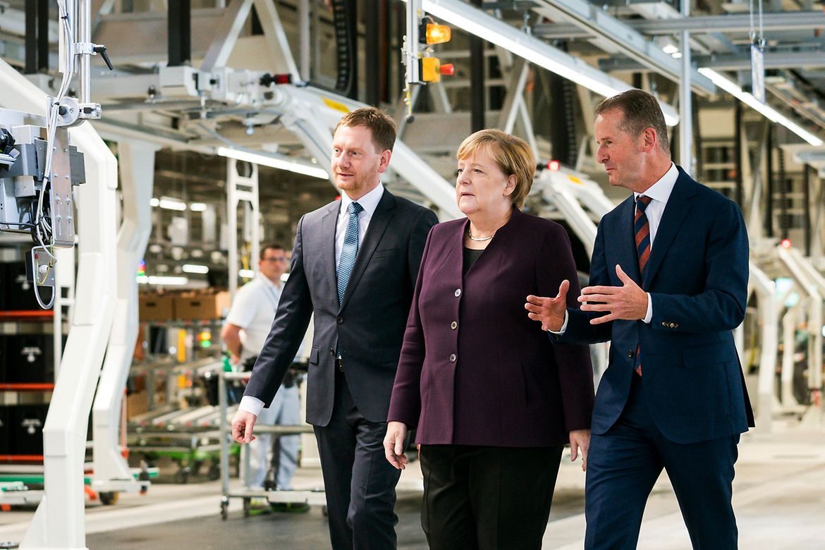 Bundeskanzlerin Angela Merkel geht bei einer Werksführung bei VW zwischen Michael Kretschmer, Ministerpräsident Sachsens, und Herbert Diess, Vorstandsvorsitzender der Volkswagen AG.