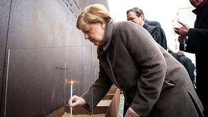 Bundeskanzlerin Angela Merkel mit einer Kerze am Denkmal für die Mauertoten an der Bernauer Straße.