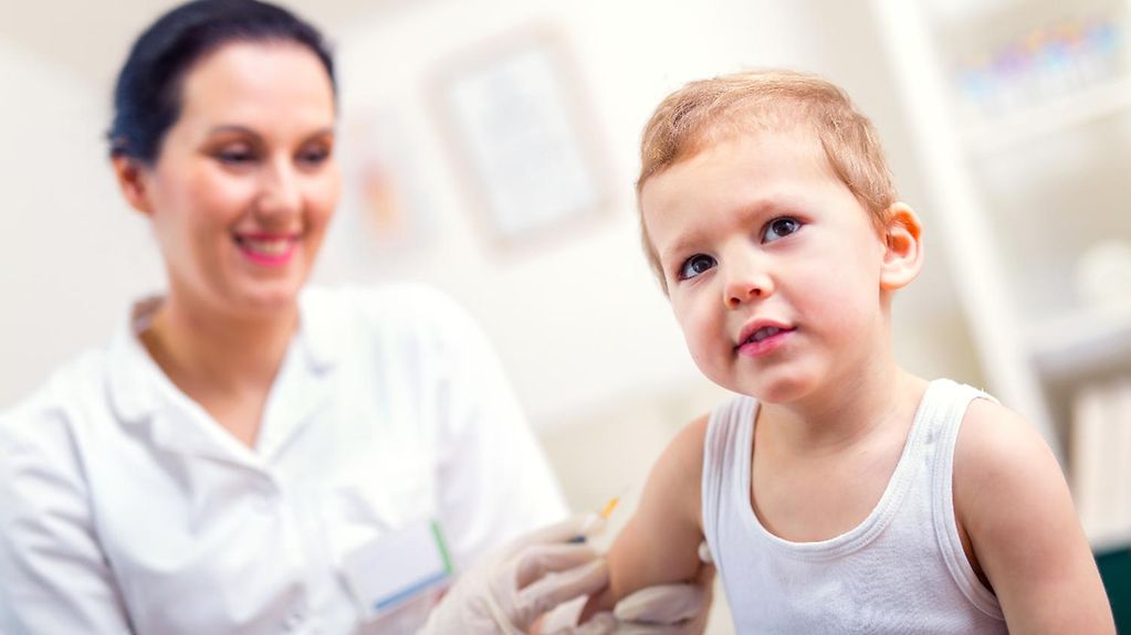 A doctor vaccinates a little boy.