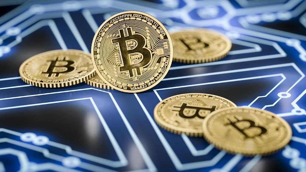 Bitcoin-Münzen auf einem dunklen elektronischen Hintergrund.