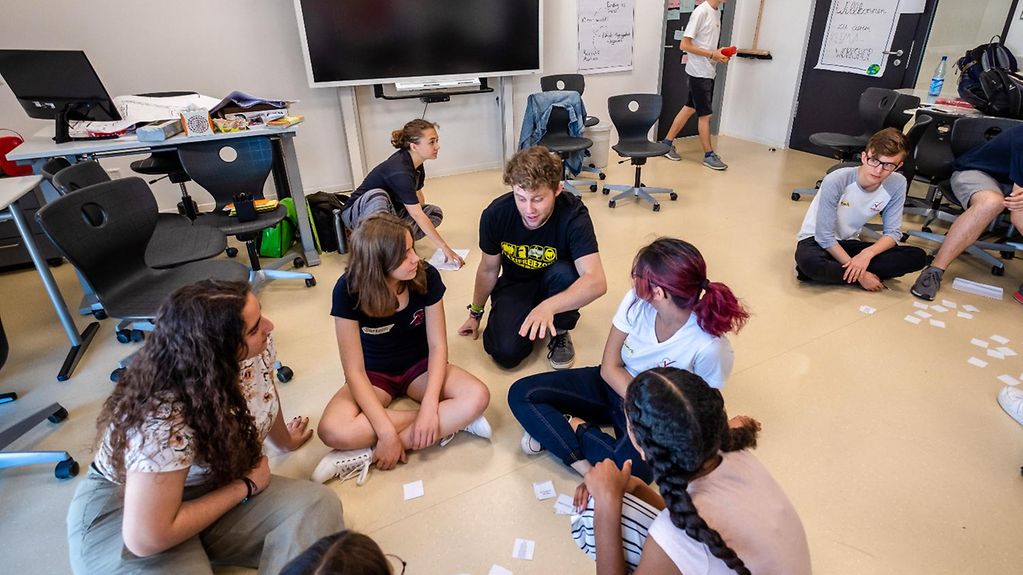 Schülerinnen und Schüler arbeiten in einem Klassenzimmer im Workshop zum Klimawandel