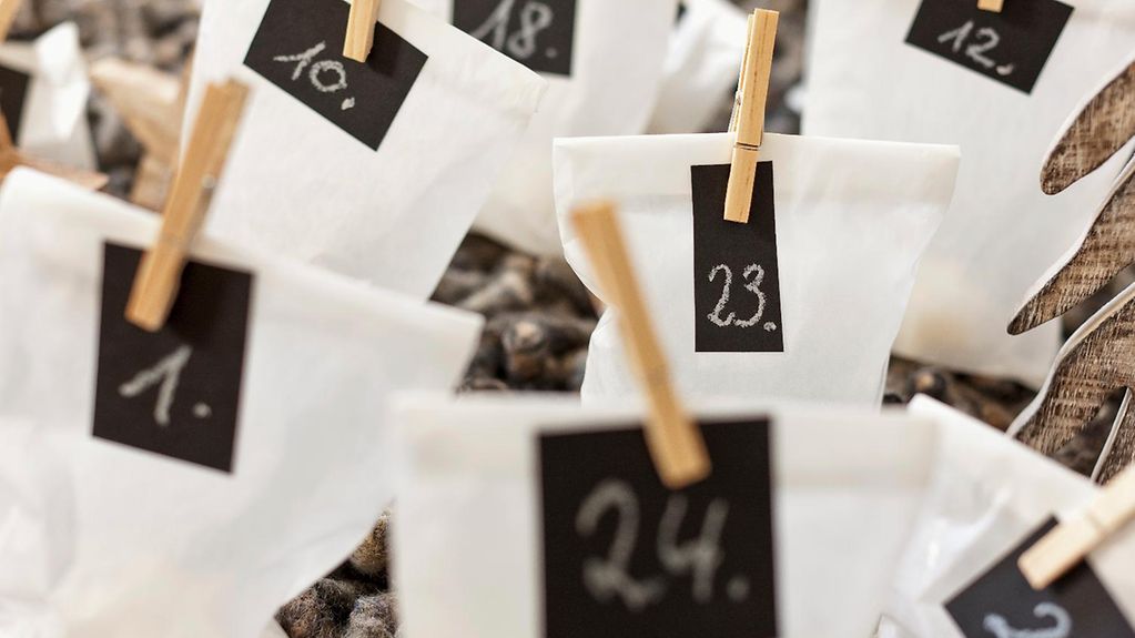 Nummerierte Tütchen eines Adventskalenders mit Wäscheklammern