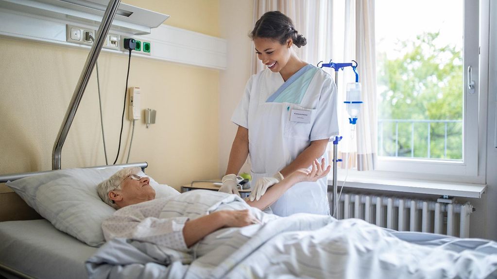 A nurse beside a patient's bed