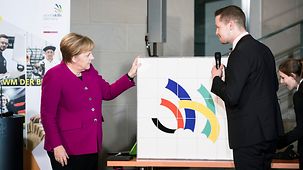 Bundeskanzlerin Angela Merkel beim Empfang der Mannschaft der internationalen Berufsweltmeisterschaften im Gespräch mit einem Teilnehmer.