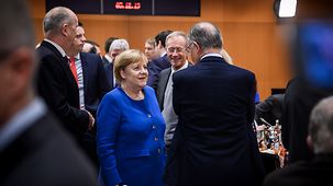 Chancellor Angela Merkel in conversation with Lower Saxony's state premier Stephan Weil