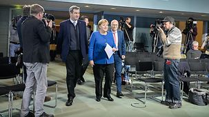 Chancellor Angela Merkel and Markus Söder, Bavarian state premier on the way to meet the press