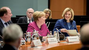 Chancellor Angela Merkel sits next to Julia Klöckner, Federal Minister of Food and Agriculture.