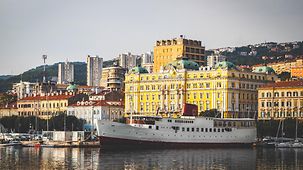 Blick auf den Hafen von Rijeka mit weißen Schiff und Stadtansicht im Hintergrund