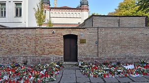 The synagogue in Halle. Countless flowers lie in front of the wall.