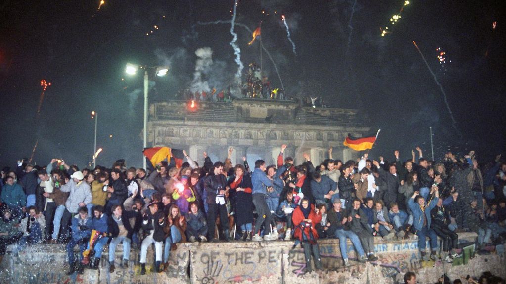 Menschen aus Ost und West feiern erstmals seit dem Bau der Mauer wieder gemeinsam Silvester am Brandenburger Tor.