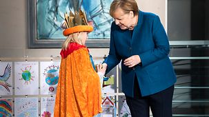 Bundeskanzlerin Angela Merkel spendet Geld beim Empfang von Sternsingern im Bundeskanzleramt.