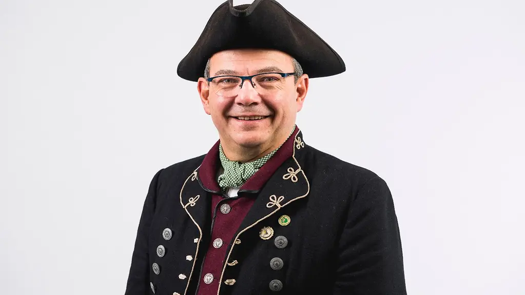 Knut Kreuch im Porträt mit hochgeschlossener Weste und Spitzhut.