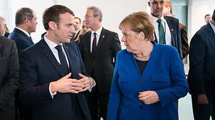 Chancellor Angela Merkel in discussion with Emmanuel Macron, French President