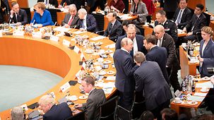 Vladimir Putin, Russia's President, in discussion with Emmanuel Macron, the French President, at the start of the Conference on Libya