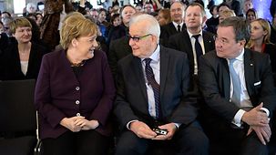 Chancellor Angela Merkel sits beside Holocaust survivor Naftali Fürst at the opening of the "Survivors" exhibition.